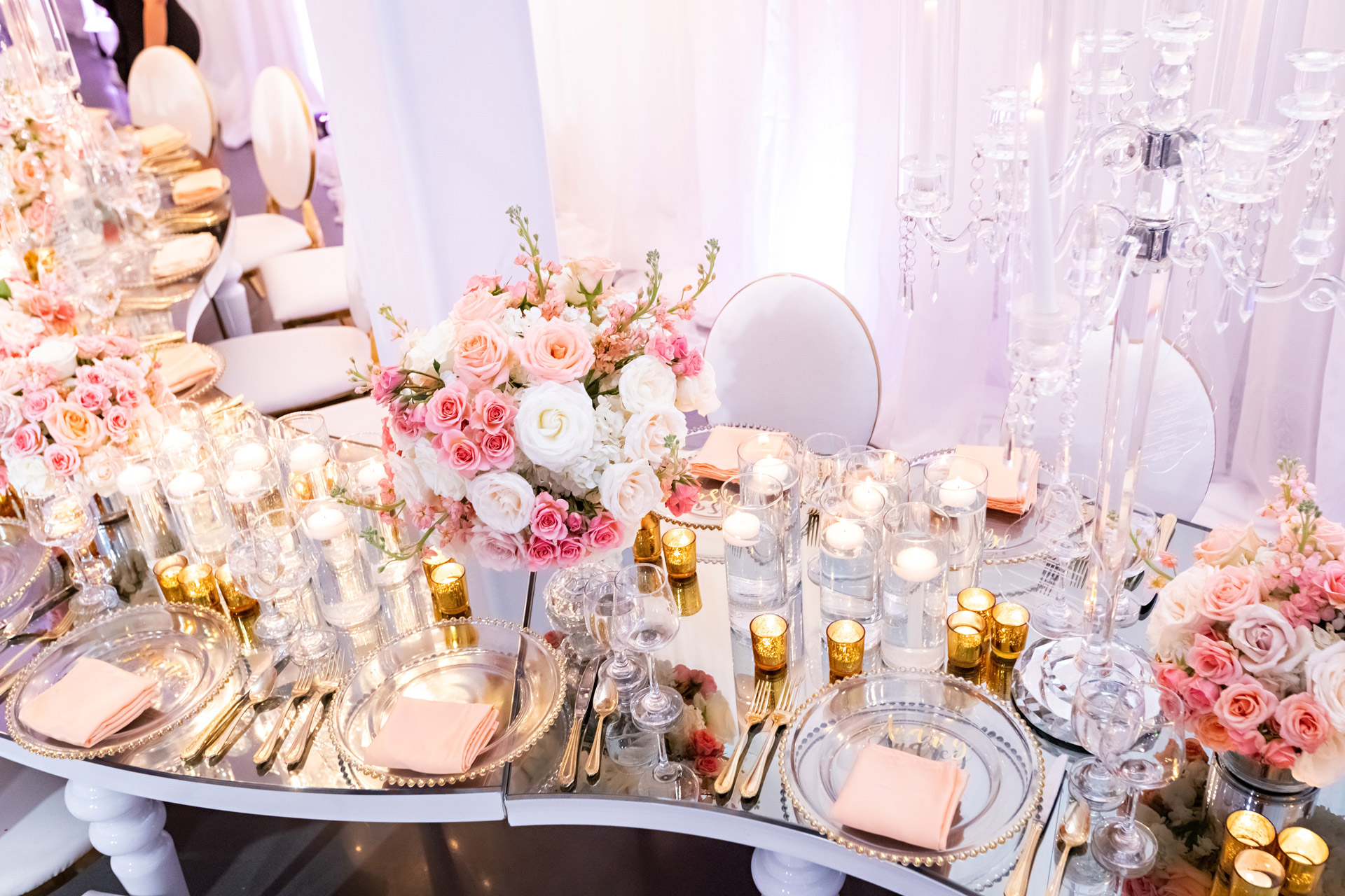 Table decorated with pink flowers and candles.